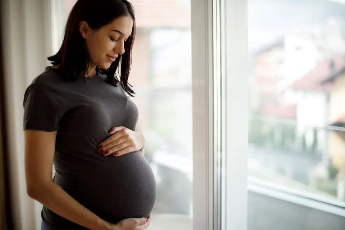 Pregnant woman preparing a healthy meal in the kitchen