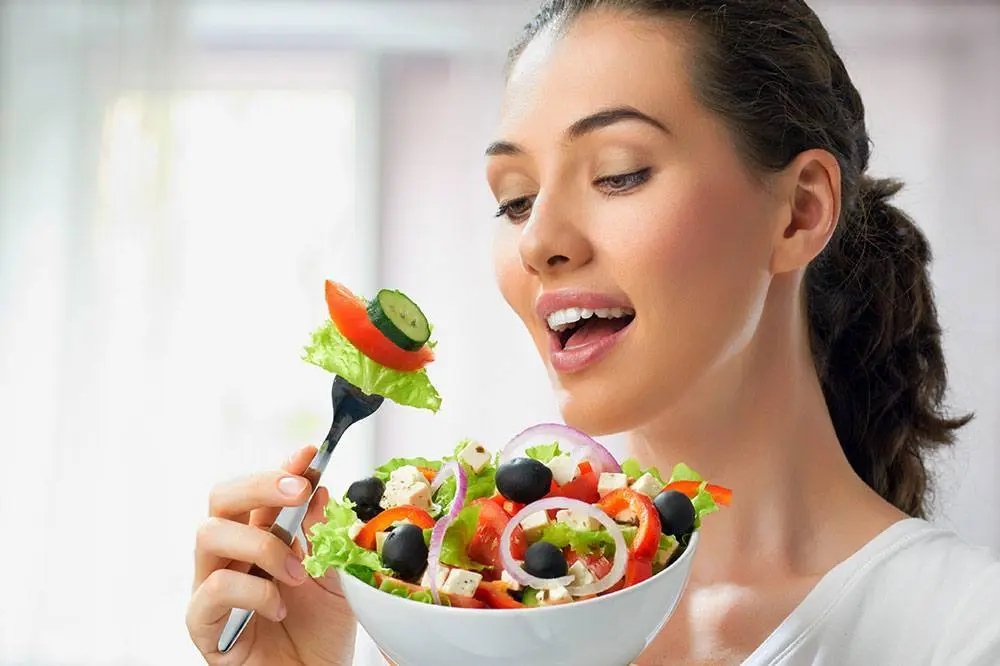 Pregnant woman preparing a healthy meal in the kitchen