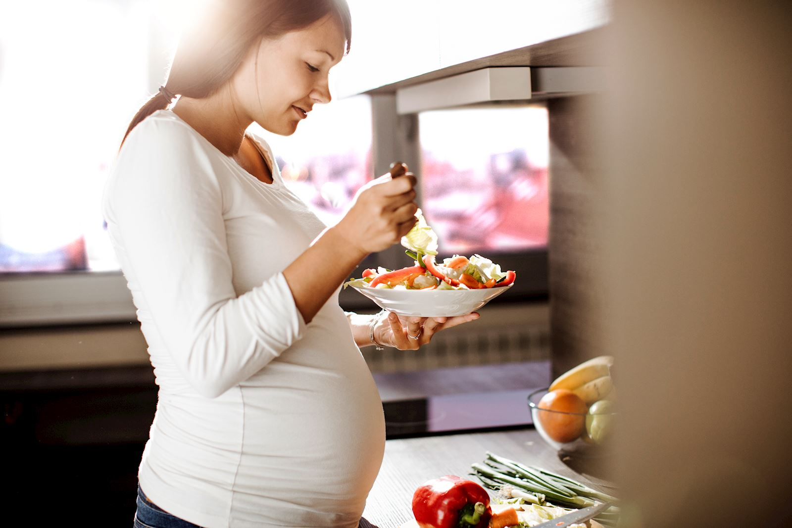 A pregnant woman preparing a healthy meal